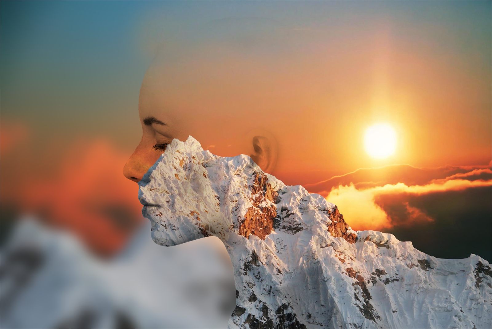 Double-exposure effect blending a woman's profile with a snow-capped mountain range at sunset