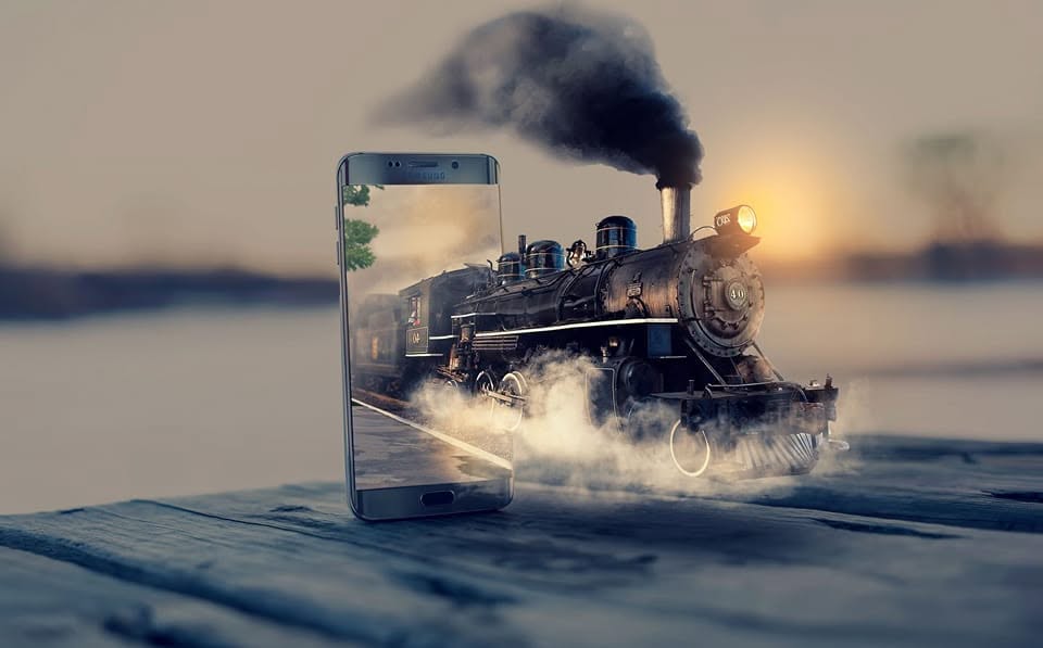 Photo composite: a steam locomotive bursting out of a smartphone screen